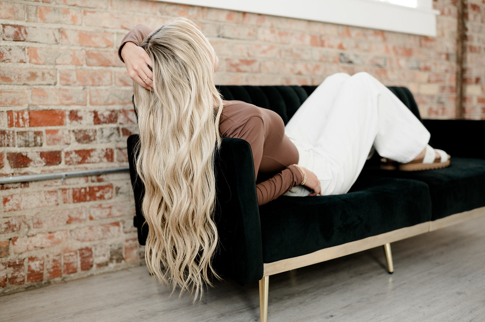 Life's Better With Extensions Couture Hair Co. Girl laying on a couch wearing Couture Hair Co. Hair extensions. Micro Weft and Keratin Bond Extensions